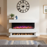 A modern white electric fireplace insert with glowing purple and orange flames, styled in a warm, contemporary living room with a gray armchair, wooden console table, and a large black Roman numeral wall clock.