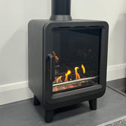 Modern black fireplace insert with visible flames on a white surface.