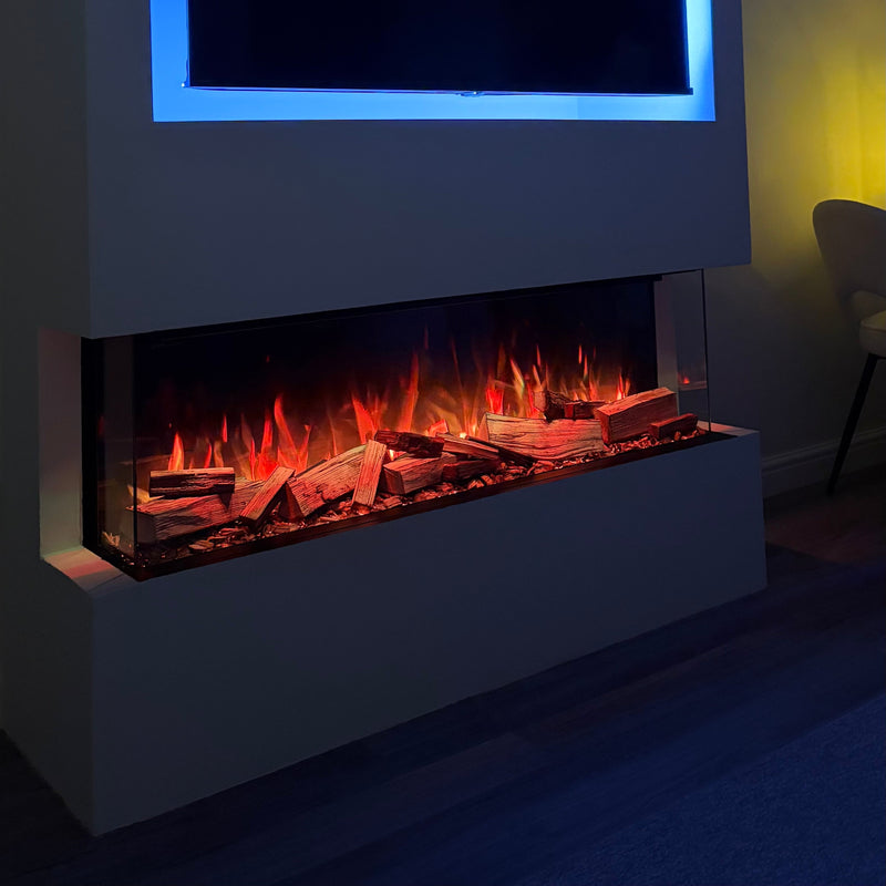 Modern electric fireplace with glowing logs and a television above it in a dimly lit room.