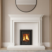 White fireplace with a fire burning between two wooden bookshelves filled with books and decorative items.