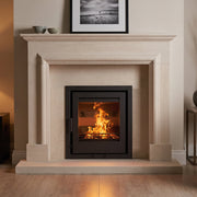 A modern black fireplace insert with a glowing orange fire, set within a light beige stone mantel and surround in a styled living room.
