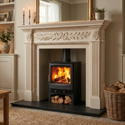 Mazona Stove in marble fireplace in cosy living room setting with logs and carpet. 