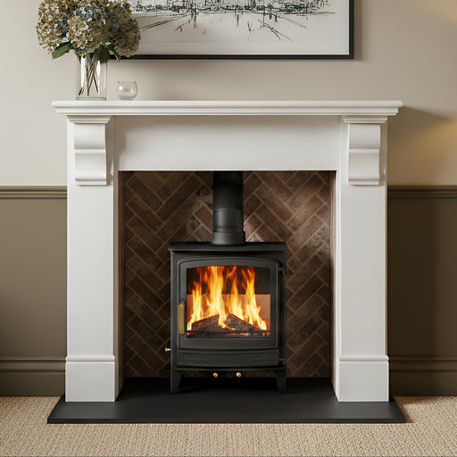 Fireplace with a lit stove, flowers in a vase on the mantel, and a framed cityscape above.