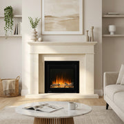 A cream-colored fireplace mantel and surround with a black electric fireplace insert, styled in a bright, modern living room with a marble coffee table, white mug, and neutral-toned sofa.